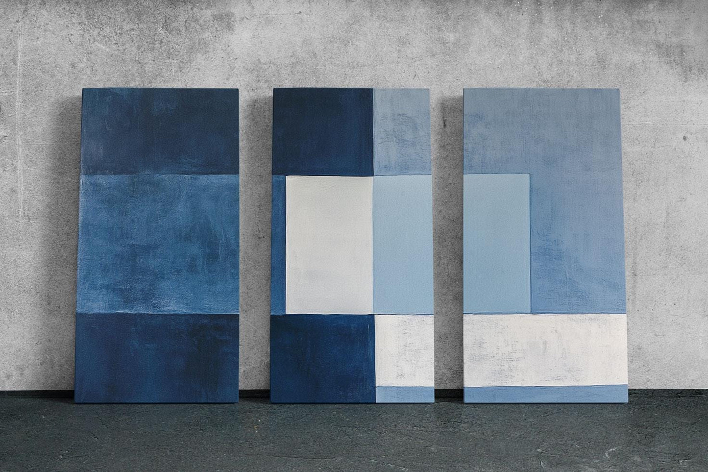 three blue and white paintings on a wall